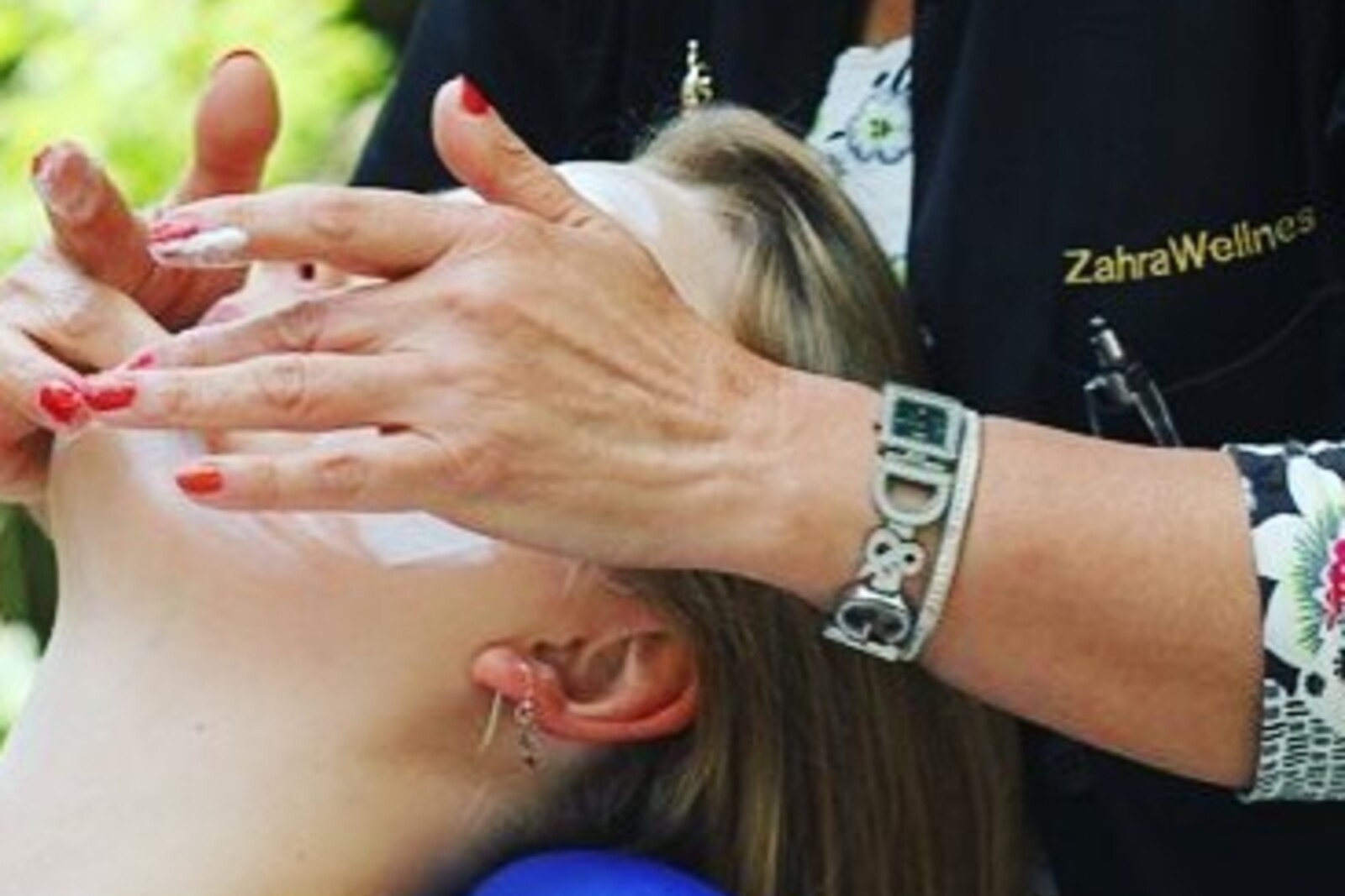 Behandlers hænder masserer en kundes skulder og nakke tæt på